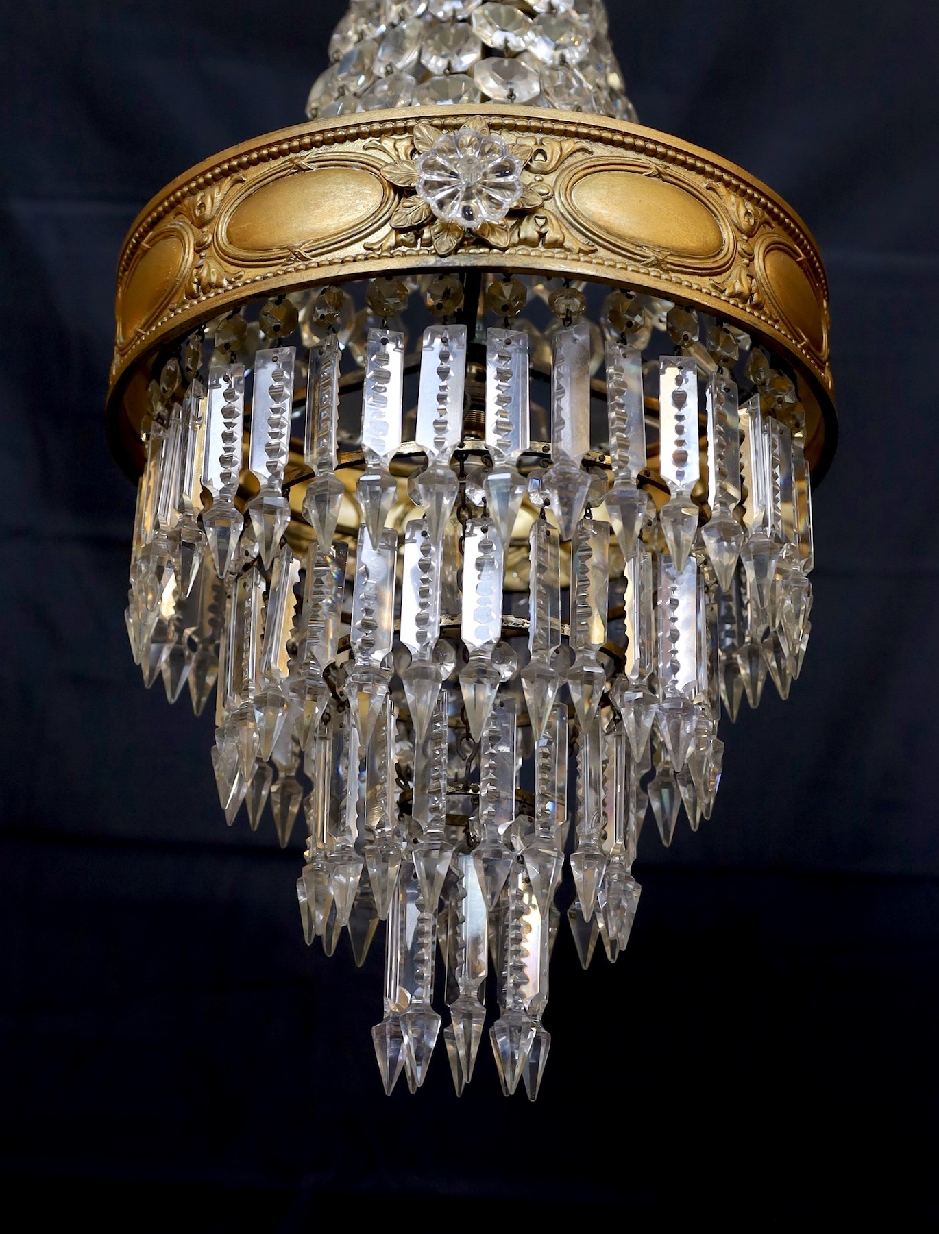 An early 20th century English ormolu and cut glass bag chandelier, hung with octagonal cut drops and spear shaped lustres with four tiers to the base, height 75cm. diameter 35cm